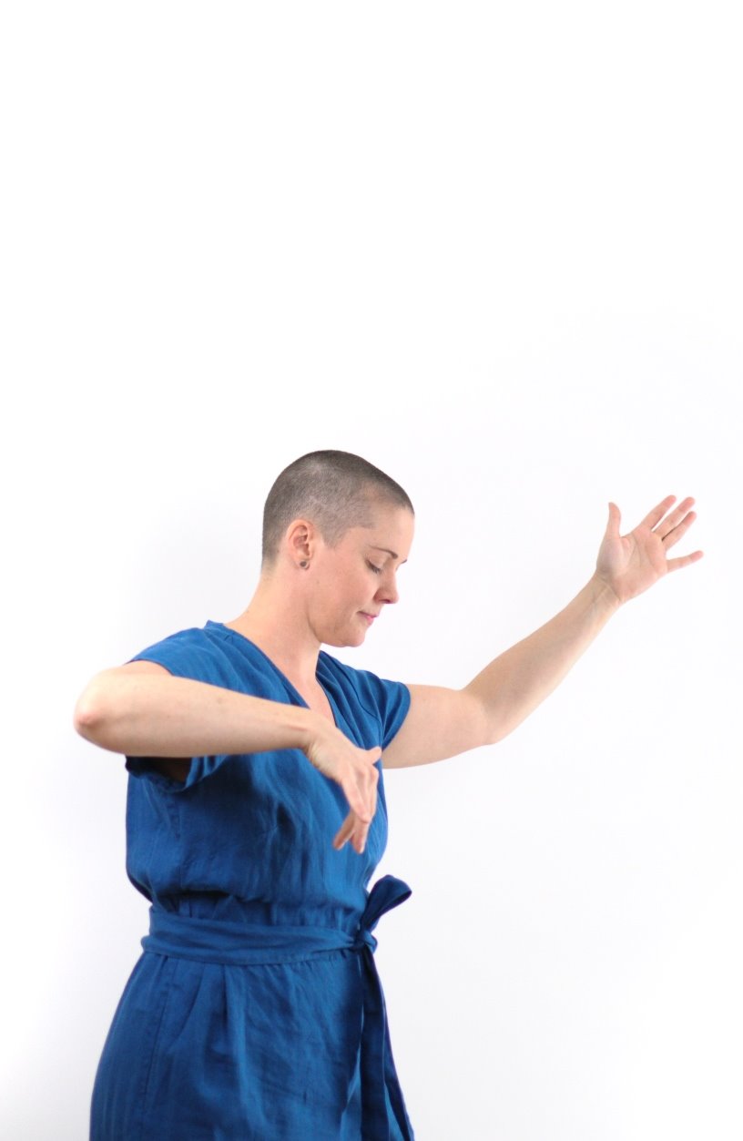 yvette in blue jumper dancing with arms in air